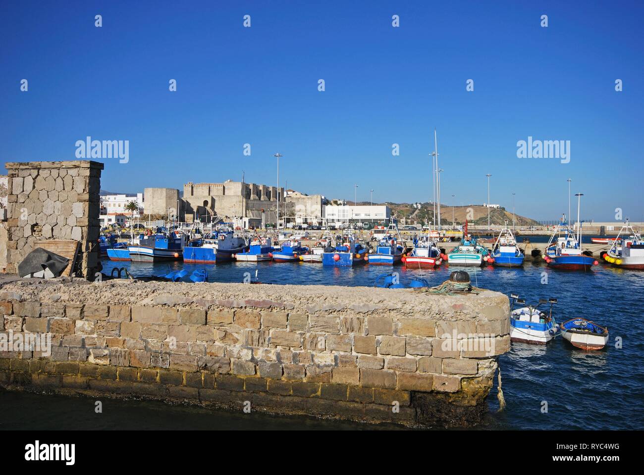 Vista delle tradizionali attività di pesca spagnola le navi per la pesca a strascico nel porto di Tarifa castello al posteriore, Tarifa, Cadice provincia, Spagna. Foto Stock