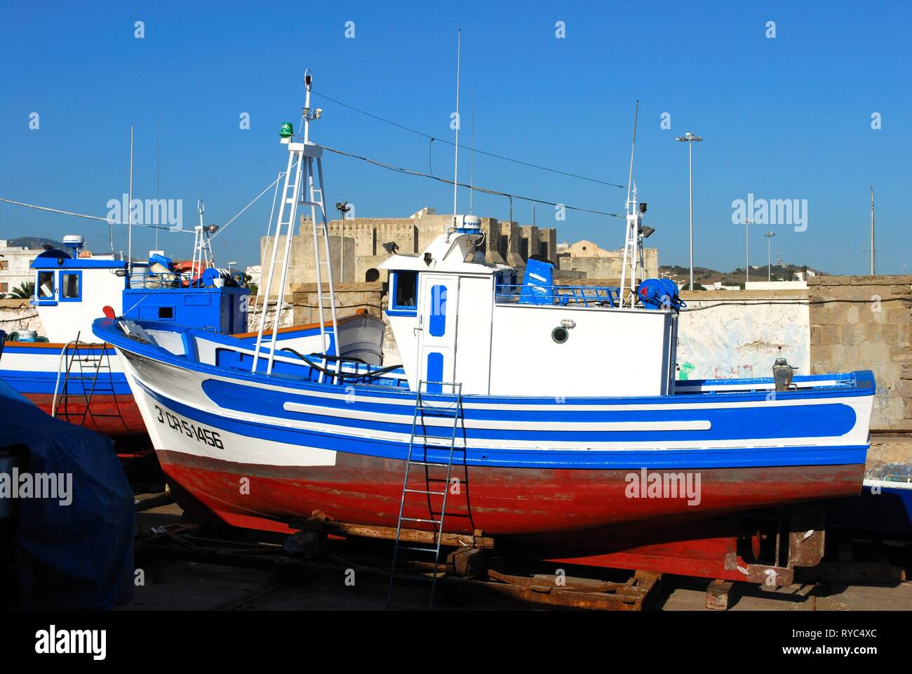 TARIFA, Spagna - 14 settembre 2008 - in vista di un tradizionale spagnolo barca da pesca nel bacino di carenaggio del porto di Tarifa castello al posteriore, Tarifa, CAD Foto Stock