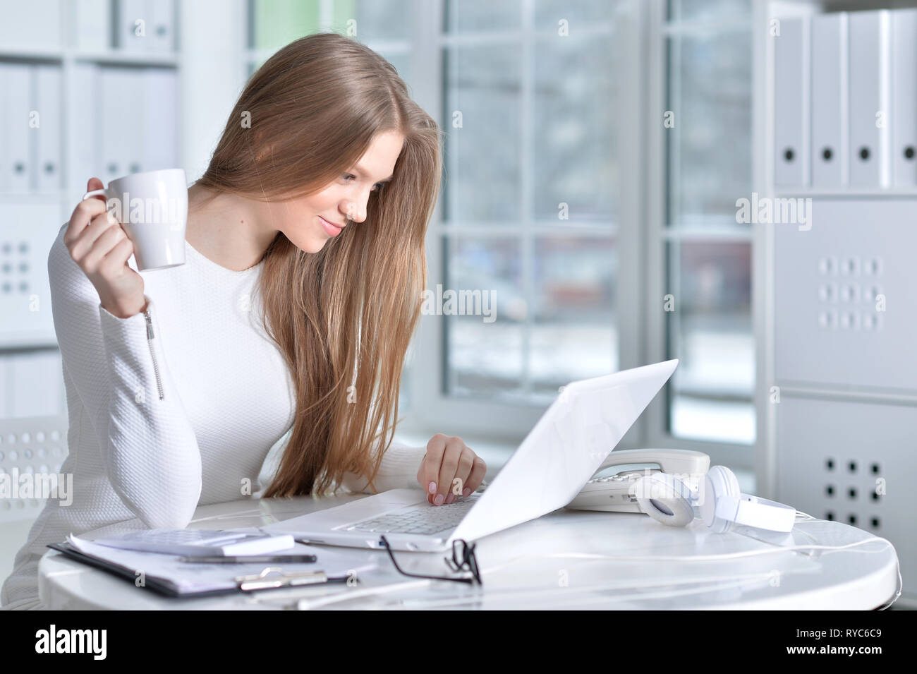 Ritratto di giovane donna che lavorano in ufficio, con il computer portatile Foto Stock