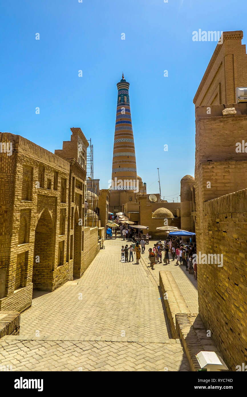 Khiva città vecchia moschea Juma e Islam Khoja Minaret con passeggiate di persone su strada Foto Stock