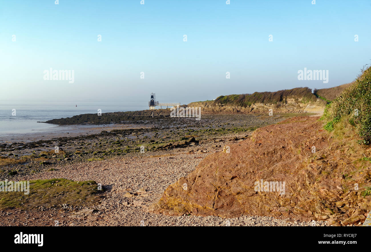 Woodhill Bay & il punto di batteria a bassa marea con Portishead punto o punto di batteria faro costruito nel 1931 Portishead, North Somerset, Regno Unito Foto Stock