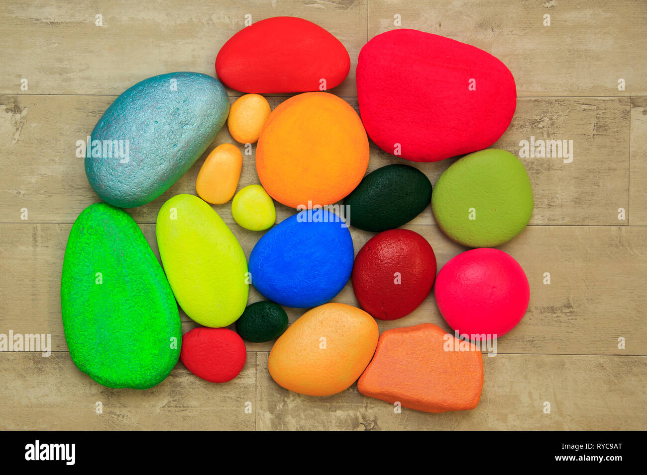 Colorate pietre dipinte su una squallida sfondo della scheda Foto Stock
