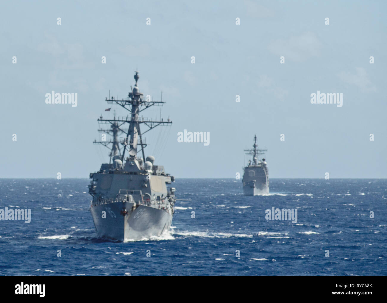 L'U.S Navy Arleigh Burke-class guidato-missile cacciatorpediniere USS McCampbell conduce la USS Milius durante le operazioni 9 marzo 2019 nel Mare delle Filippine. Foto Stock
