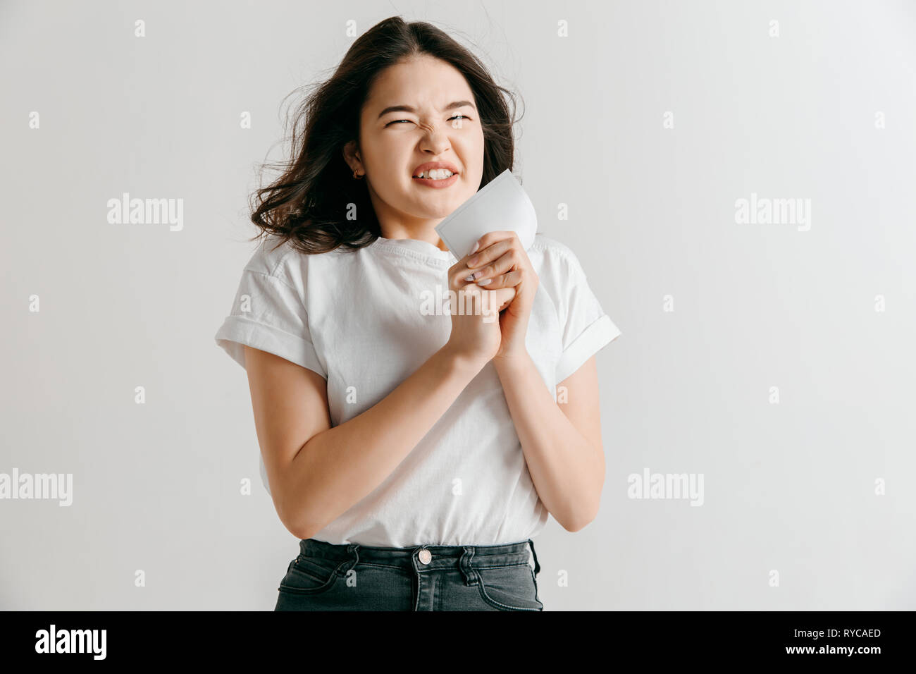 Giovane donna asiatica con una sorpresa felice espressione ha vinto la scommessa su sfondo per studio. Viso umano emozioni e concetto di scommesse. Colori alla moda Foto Stock