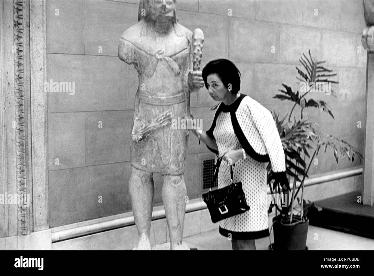 Una donna bussa su una antica statua per controllare se si tratta di pietra o legno. New York 1969. USA la sua pietra. .60s NOI HOMER SYKES Foto Stock