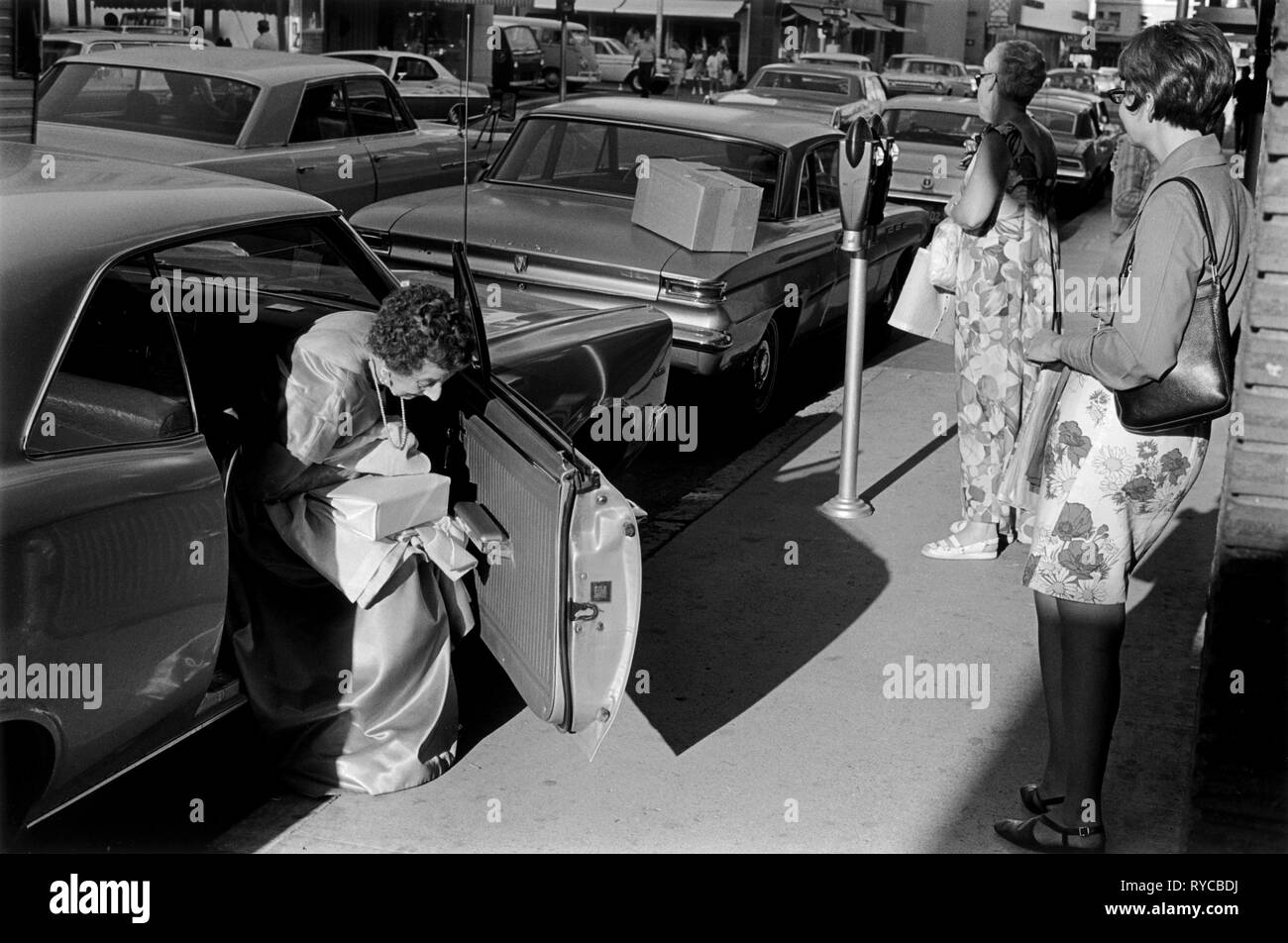 Reno, Nevada, USA, anni '1960, signore che mettono soldi nel parchimetro prima di andare al casinò indossando un abito da ballo. 60s 1969 HOMER SYKES Foto Stock