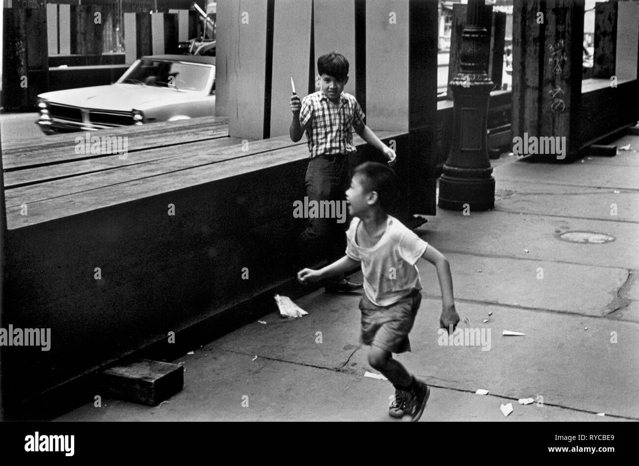 Giocando con i coltelli, US STATI UNITI D'America degli anni sessanta di New York. USA due ragazzi fanno finta di lotta Manhattan street notte tempo. Noi 60s HOMER SYKES Foto Stock
