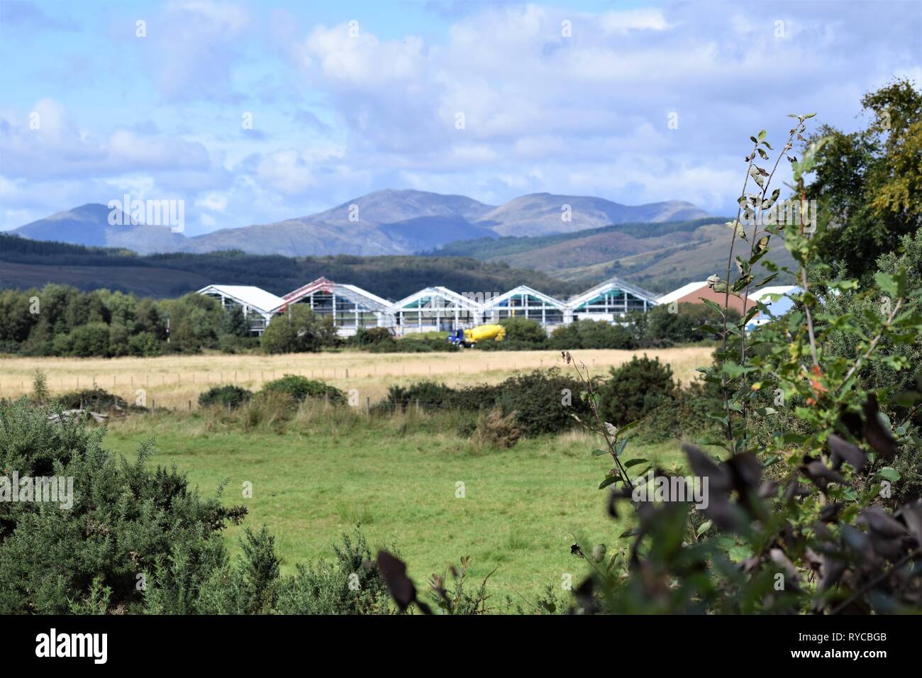 Mare scozzese Aziende agricole' Salmon Hatchery edificio durante la costruzione a Barcaldine, Argyll. Colline e cielo. Foto Stock