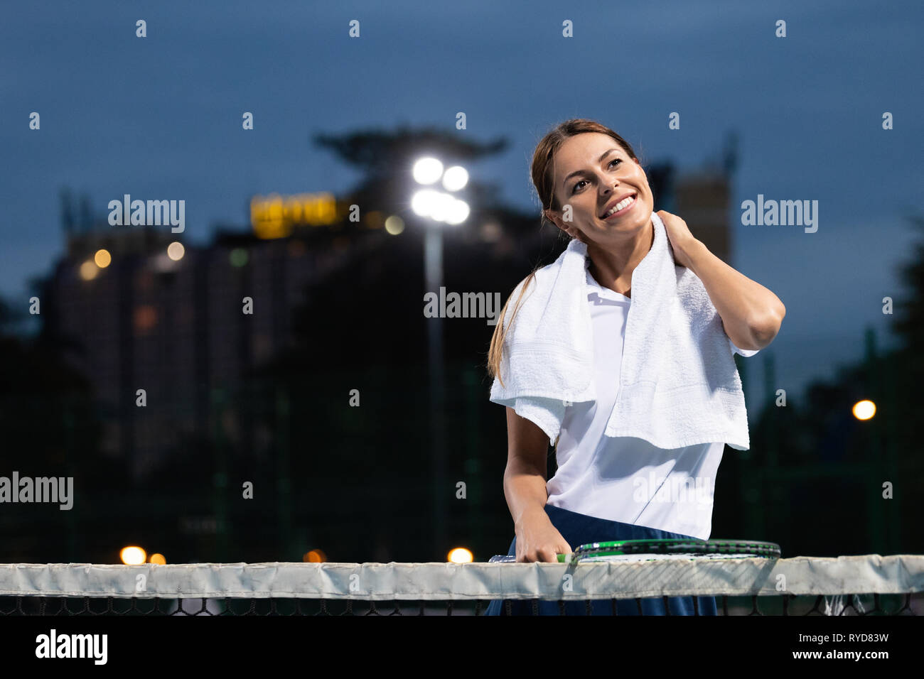 Donna giocatore di tennis con pregiudizio tenendo la racchetta su un campo da tennis Foto Stock