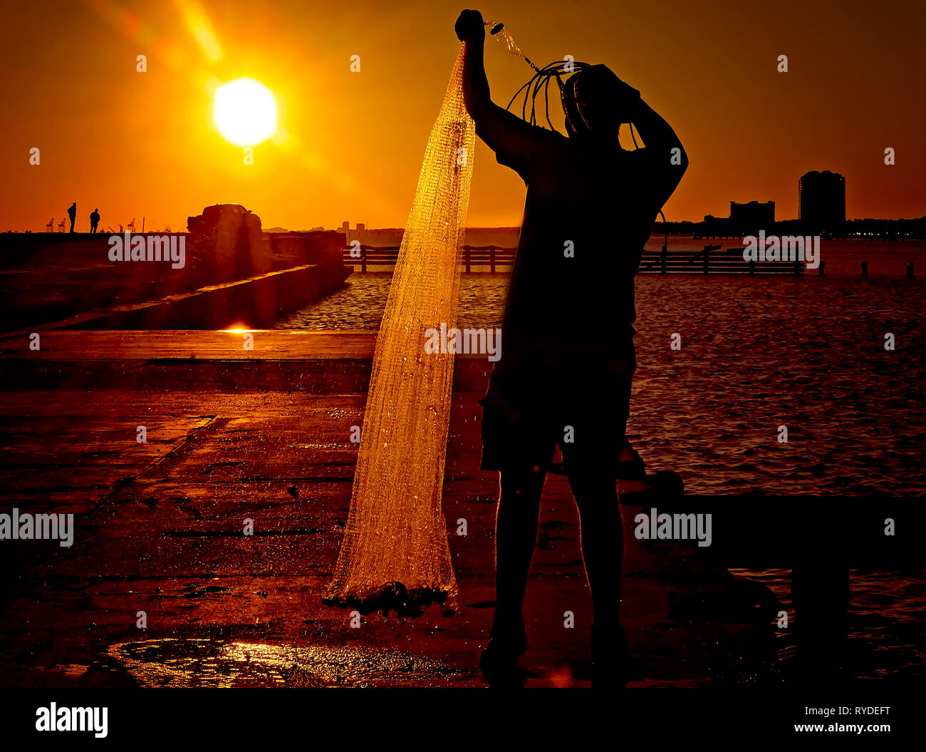 Un uomo getta un rombo liscio net presso il Broadwater Beach Marina, febbraio 24, 2019, in Biloxi Mississippi. Il resort è stata distrutta da diversi uragani. Foto Stock