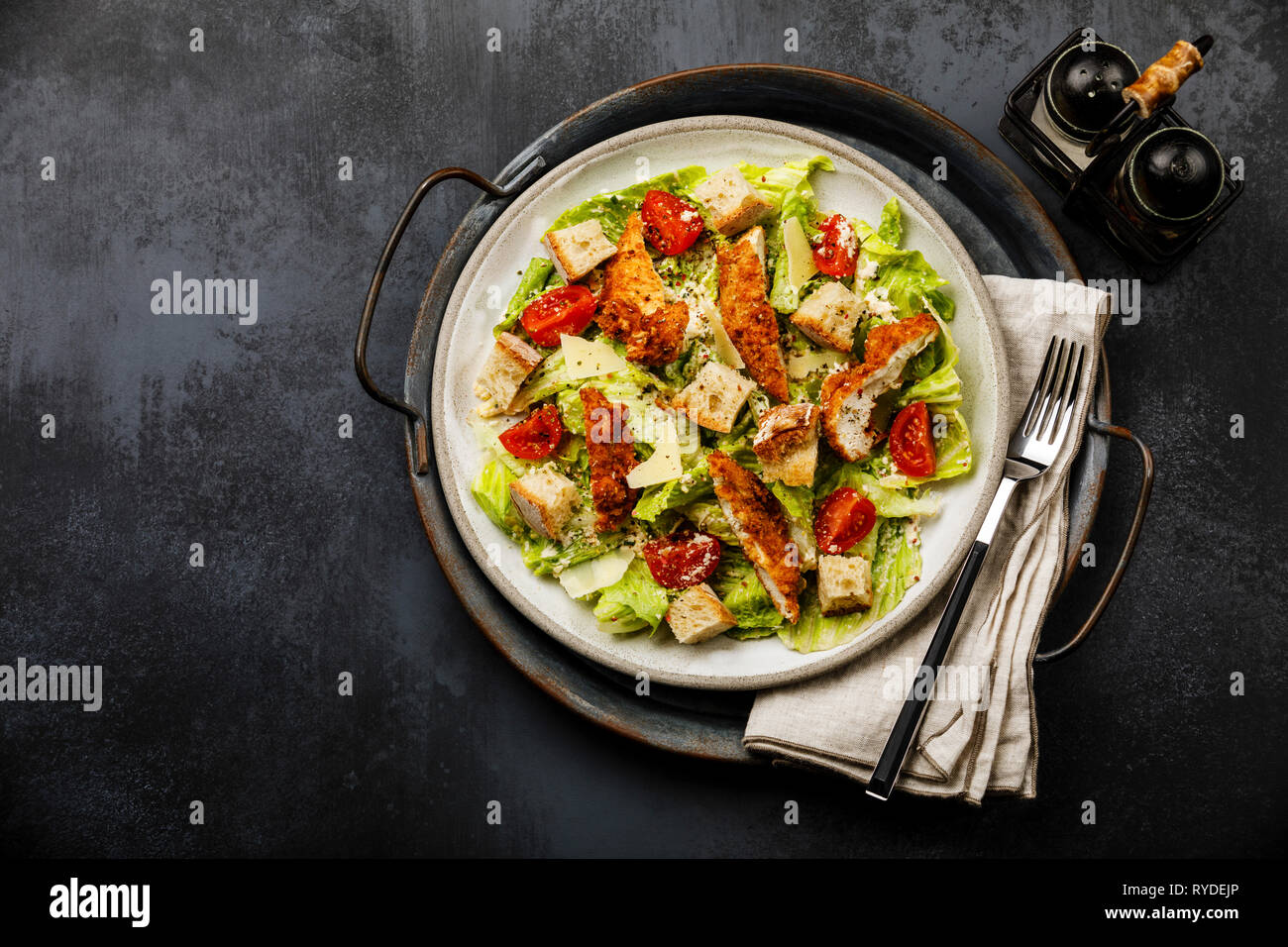 Caesar insalata con petto di pollo carne sul vassoio di metallo su sfondo scuro spazio copia Foto Stock