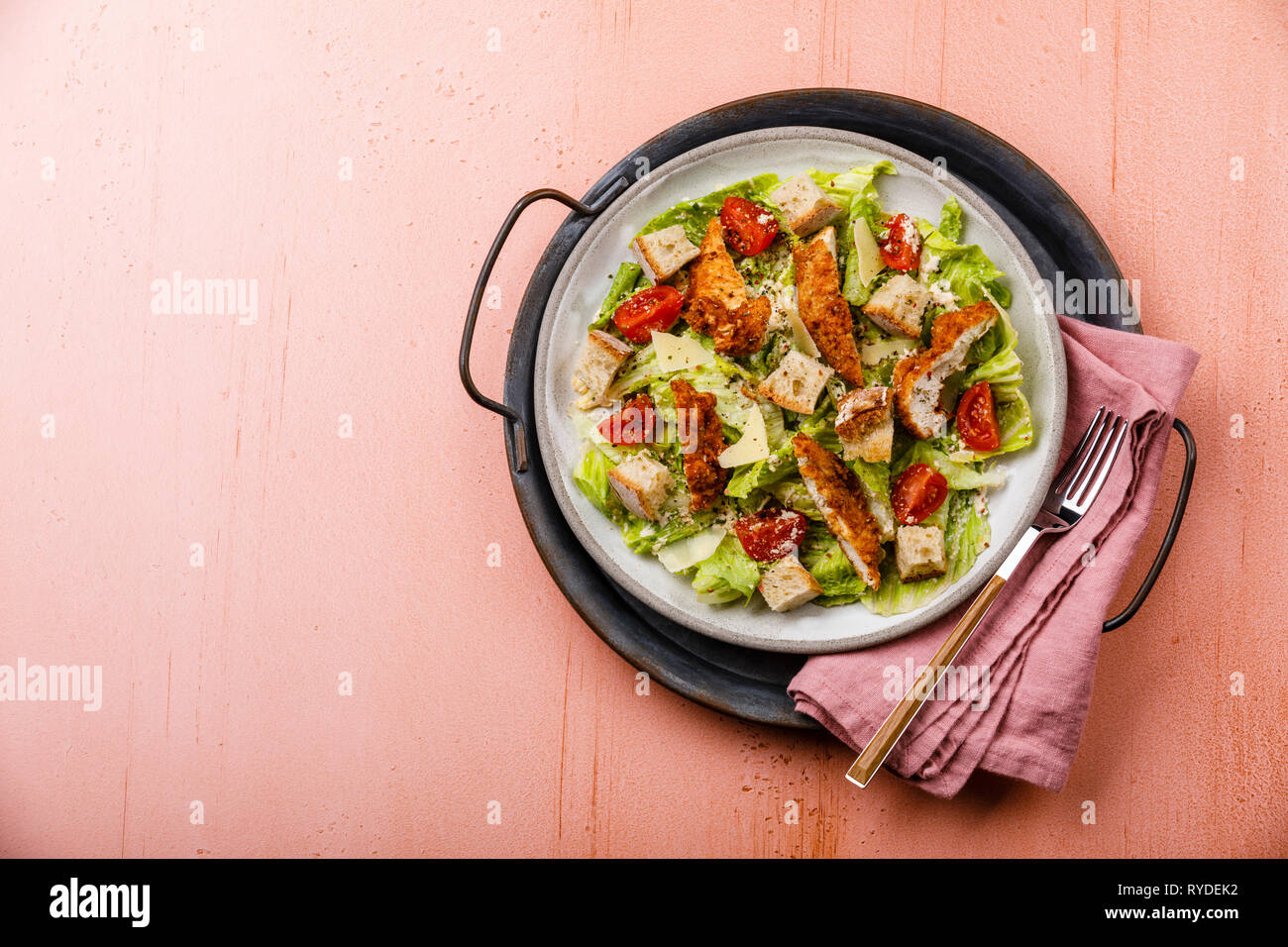 Caesar insalata con petto di pollo carne sul vassoio di metallo su sfondo rosa spazio copia Foto Stock