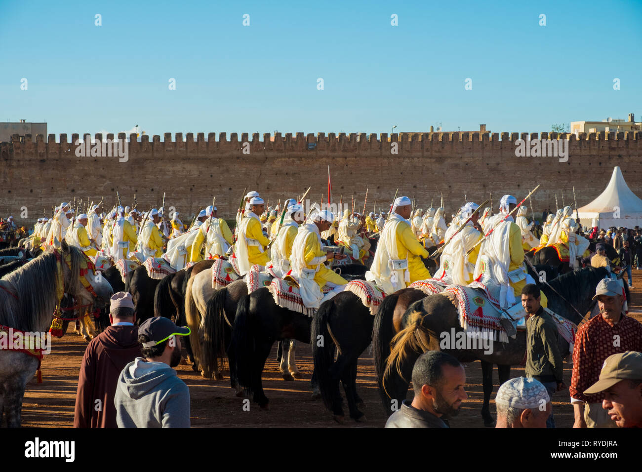 Meknes, Marocco - Marzo 31, 2018: uniformata gruppo tribale con fucili montati su cavalli in attesa di Tbourida Fantasia vicino a Medina parete in Meknes, Moroc Foto Stock