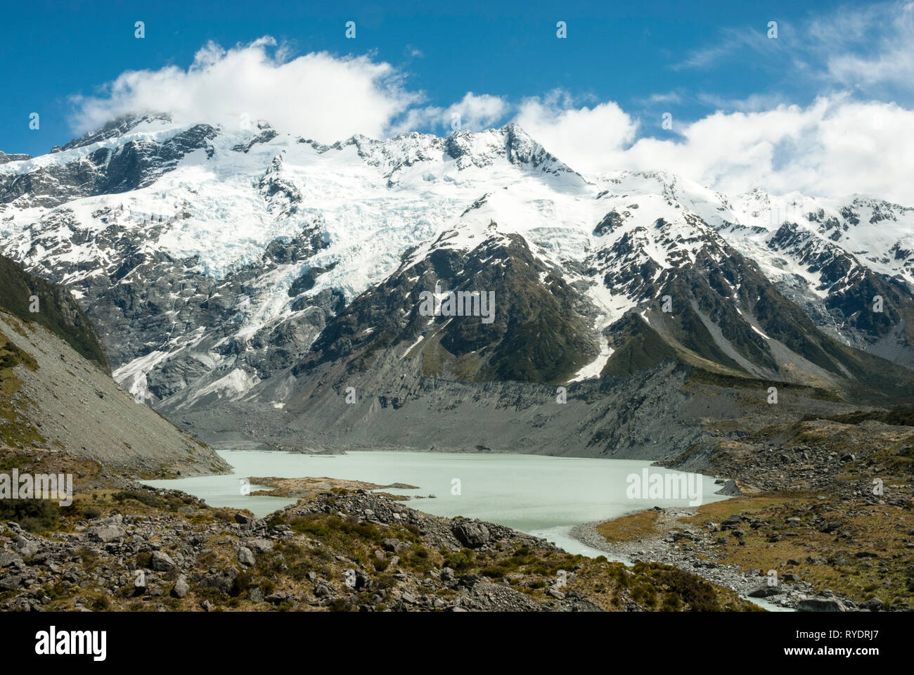 L'acqua di fusione del ghiaccio in Mueller lago sottostante Snow capped Mount Sefton, NZ, nelle Alpi del sud in una giornata di sole in primavera. Foto Stock