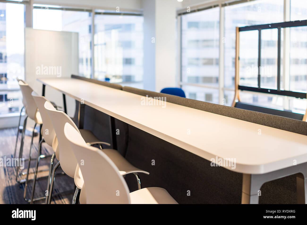 Moderno ufficio vuoto sala da pranzo cucina bar nell'edificio di legno di business aziendale tabella closeup dal vetro della finestra e molte sedie di riga nessuno Foto Stock