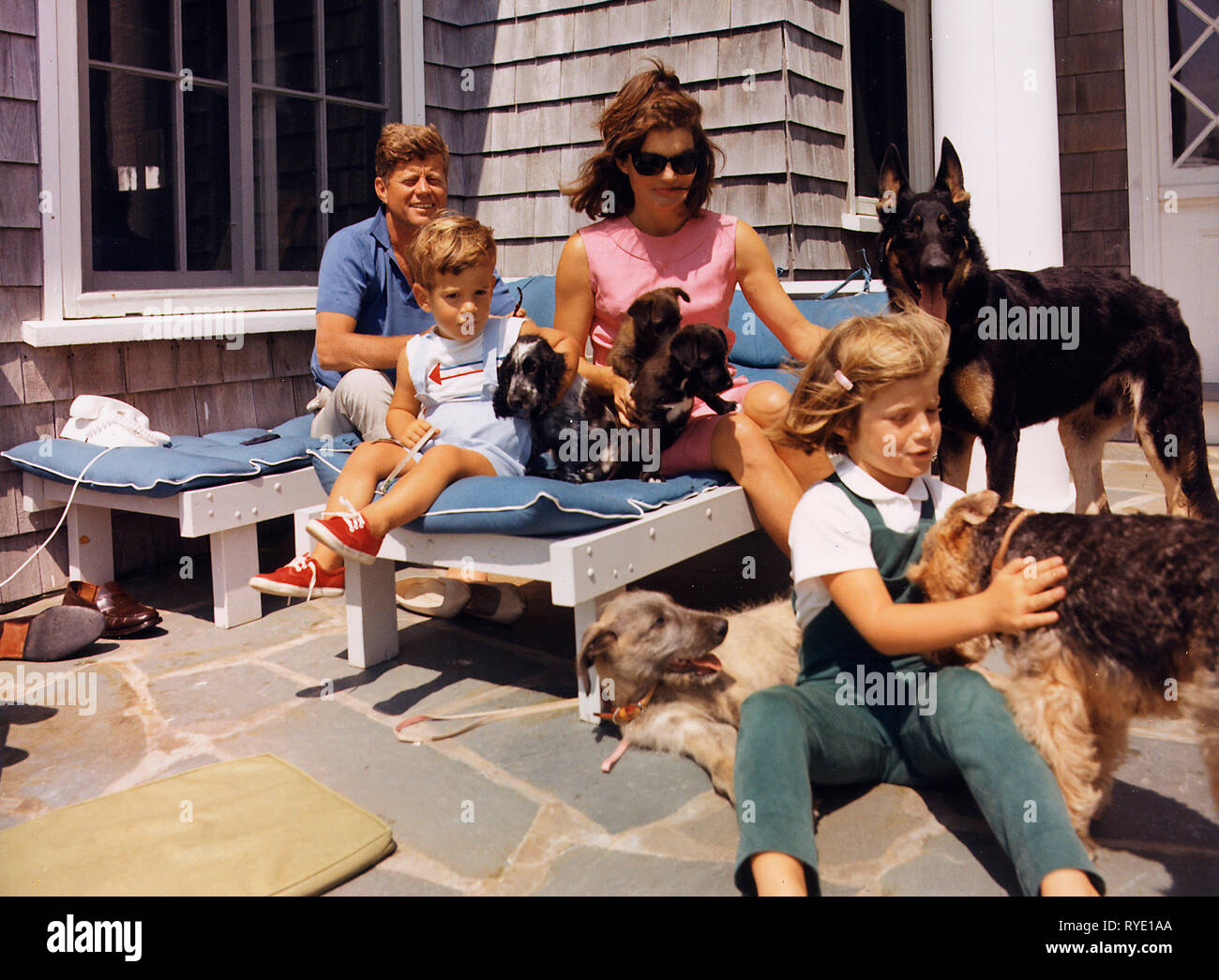 Famiglia Kennedy con cani durante un weekend a Hyannisport - Hyannisport Weekend. Presidente Kennedy, John F. Kennedy Jr., la sig.ra Kennedy, Caroline Kennedy. Cani: Clipper ( in piedi ), Charlie ( con Caroline ), lupo ( ) reclinabili, Shannon ( con Giovanni Jr. ), due di Pushinka's cuccioli ( con la sig.ra Kennedy ). Agosto 1963 Foto Stock