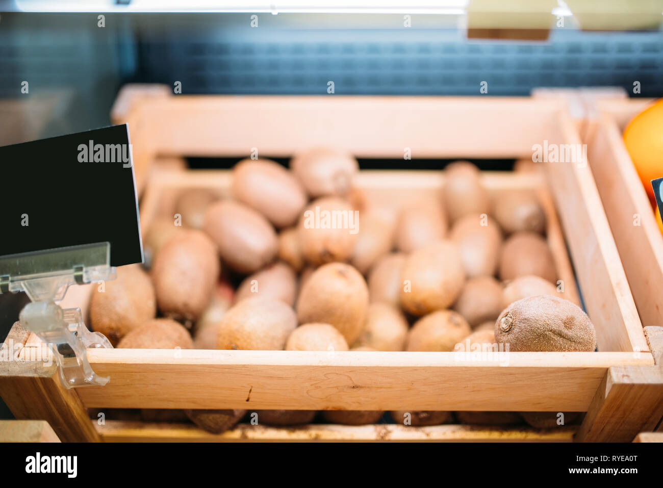 Scatola con fresche kiwi su supporto in un negozio di alimentari, nessuno Foto Stock