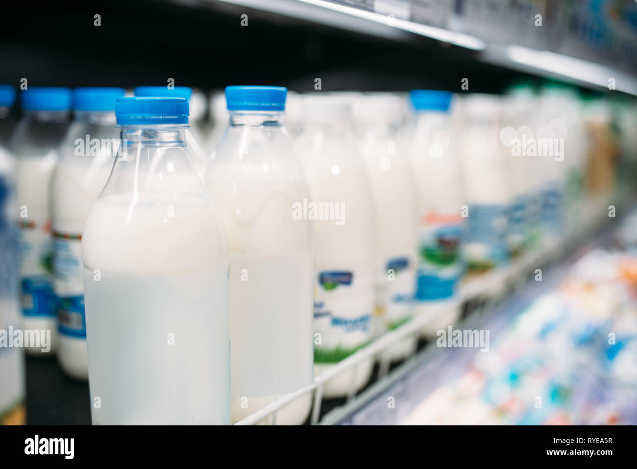 Fila di bottiglie di latte in frigorifero, un negozio di alimentari, nessuno Foto Stock