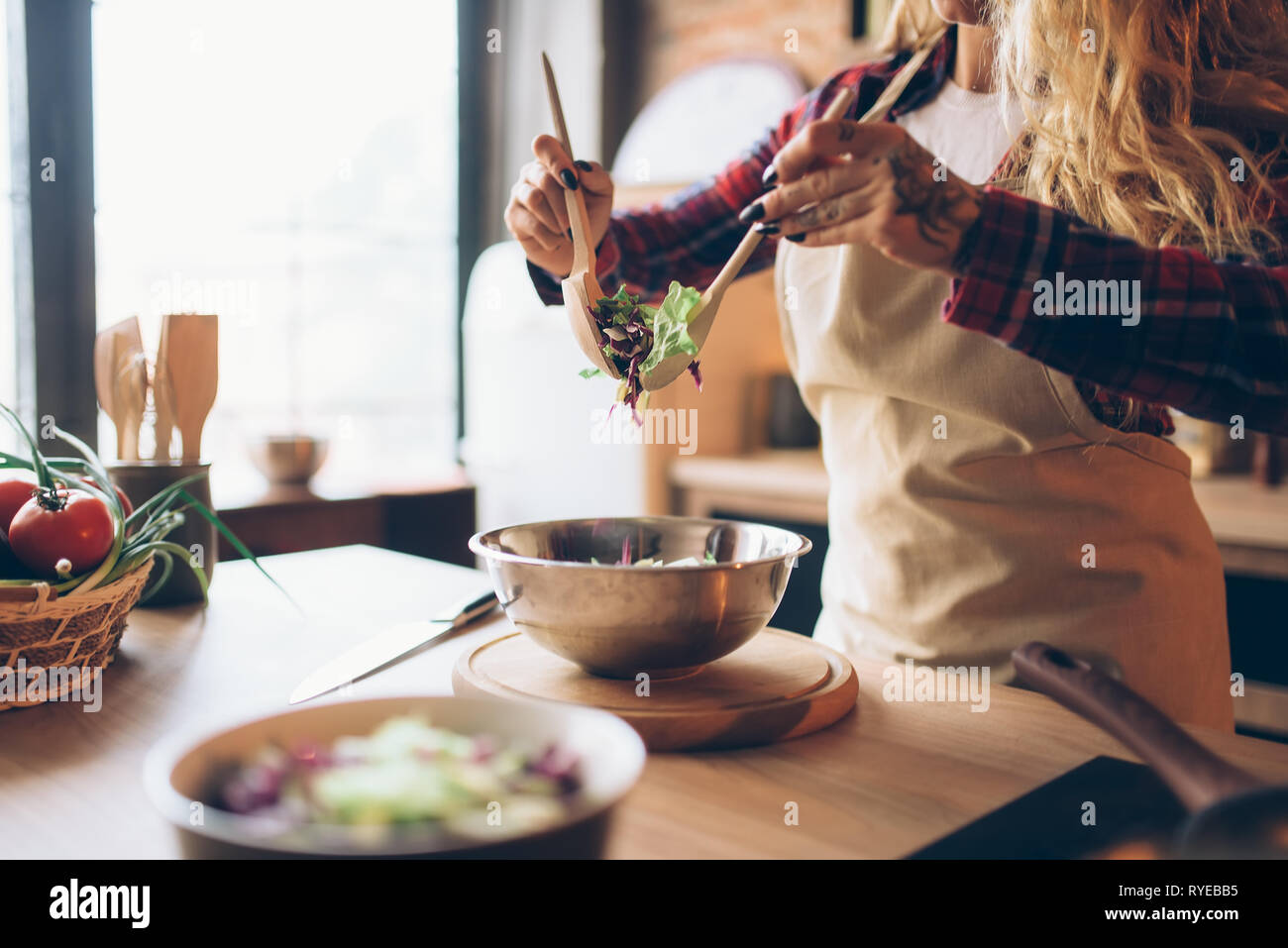 Massaia nella cottura della catenaria insalata fresca su cucina Foto Stock