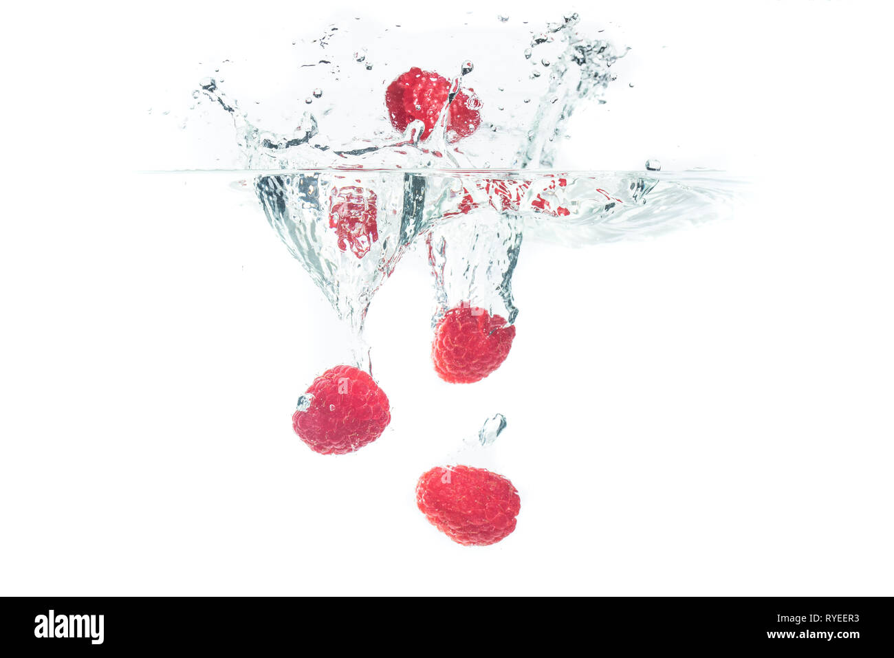 Mazzetto di succosa deliziosi lamponi cercando di spruzzi di acqua in superficie e affondamento. Isolato su sfondo bianco, splash cibo fotografia. Foto Stock