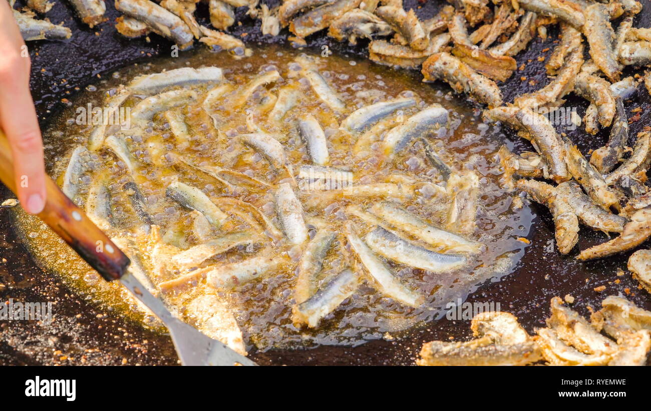 La cottura di aringa del Baltico pesce sulla hot pot con un sacco di lato ed alcuni cotti su l'olio Foto Stock