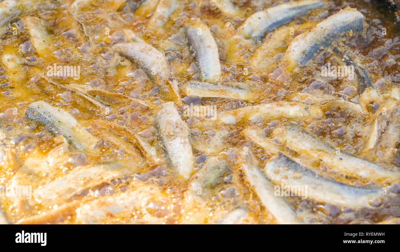 L'olio caldo per la cottura di aringa del Baltico pesce sulla pentola per essere servito al popolo Foto Stock