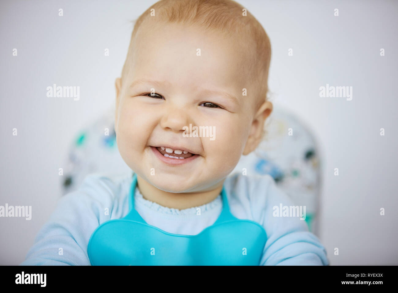 Happy Baby girl indossando bib e avrà il suo pasto Foto Stock