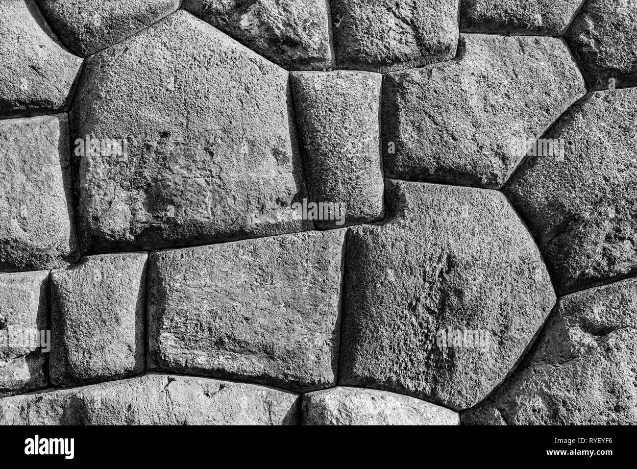 Fotografia in bianco e nero dei grandi blocchi di granito utilizzato nella costruzione della fortezza Inca di Sacsayhuaman, città di Cusco, Perù. Foto Stock
