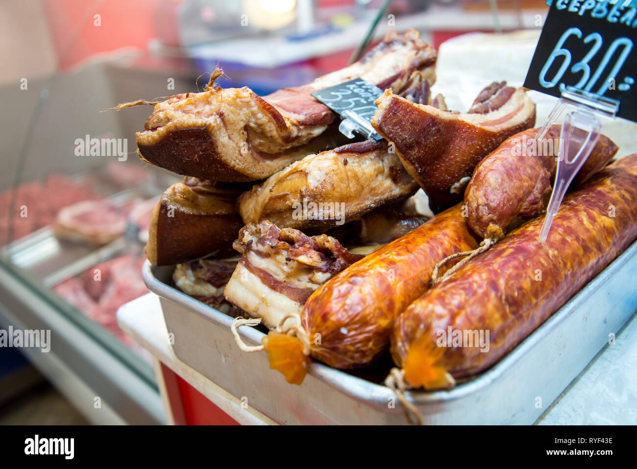 Grande pila di tutta la pancetta. Grande la pancetta affumicata. Salsiccia affumicata. Salate strutto. Iscrizione in russo: pancetta affumicata, Cracovia salsiccia. Foto Stock