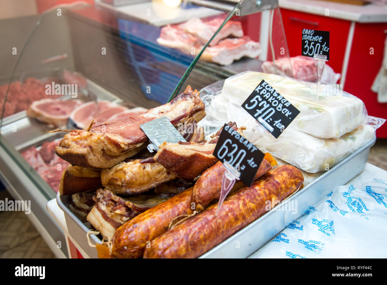 Grande pila di tutta la pancetta. Grande la pancetta affumicata. Salsiccia affumicata. Salate strutto. Iscrizione in russo: pancetta affumicata, Cracovia salsiccia. Foto Stock