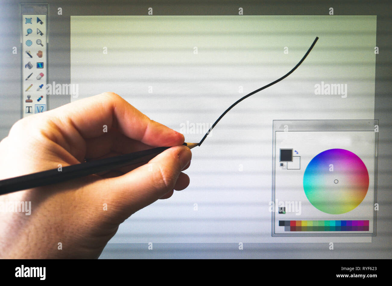 Editor grafico softwares - Una mano con una matita disegnare sullo schermo del computer Foto Stock