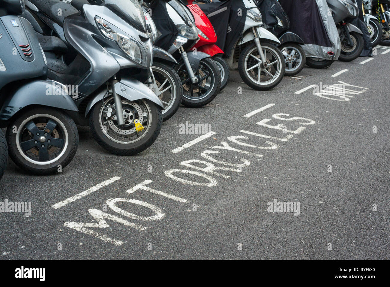 Una fila di moto scooter parcheggiato in una moto solo il rango di Soho, Londra. Foto Stock