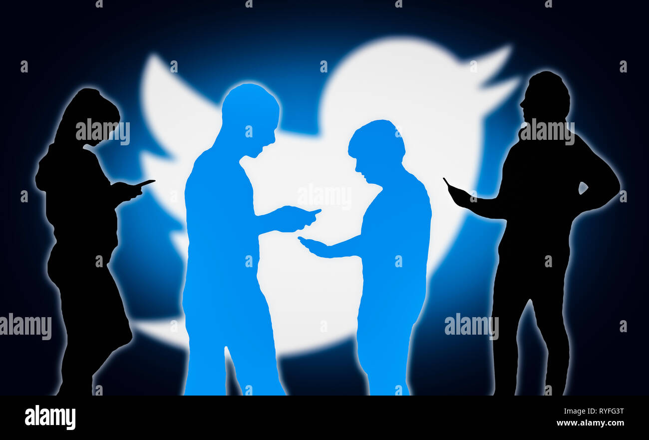 Sagome di un gruppo di persone con dispositivi mobili utilizzando l'applicazione Twitter. Foto Stock
