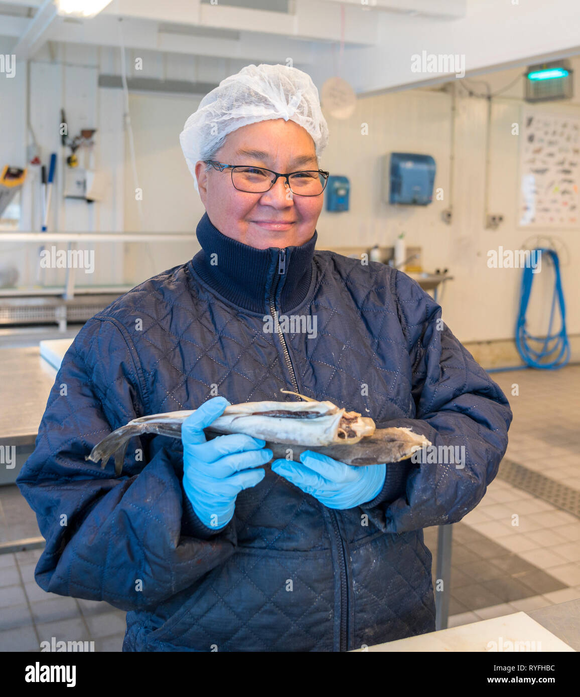 Donna che mantiene un merluzzo, Qaqortoq, Groenlandia meridionale Foto Stock