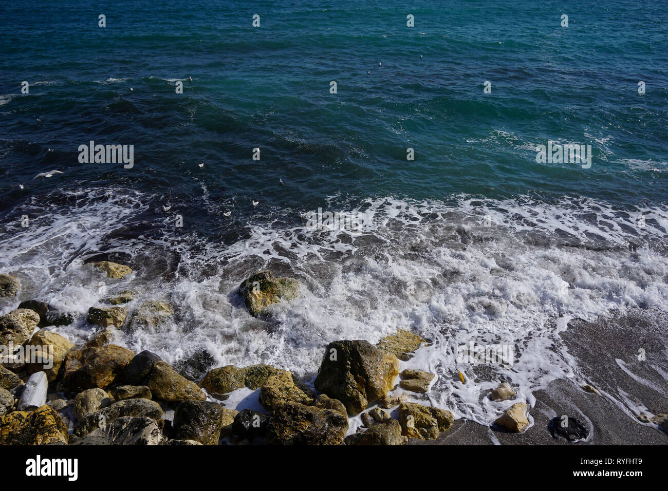 Le onde che si infrangono in rocce Foto Stock