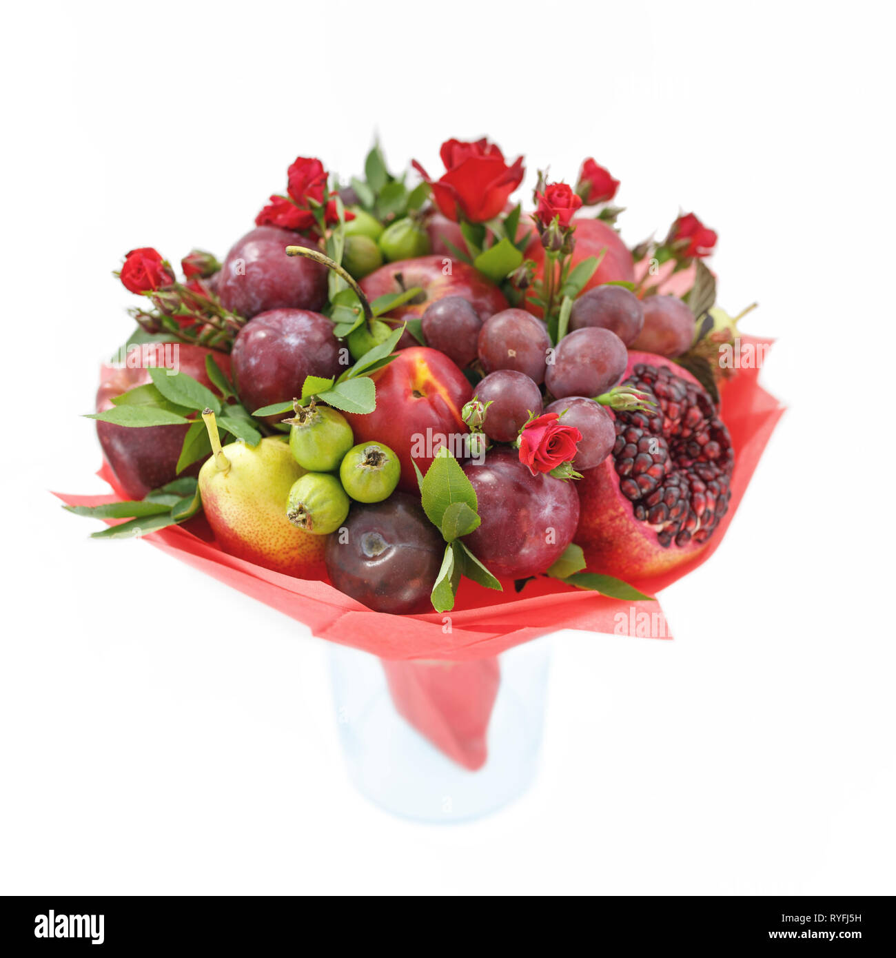 Bouquet commestibile costituito di melograno, mele, susine e scarlet rose in piedi in un vaso isolato su sfondo bianco Foto Stock