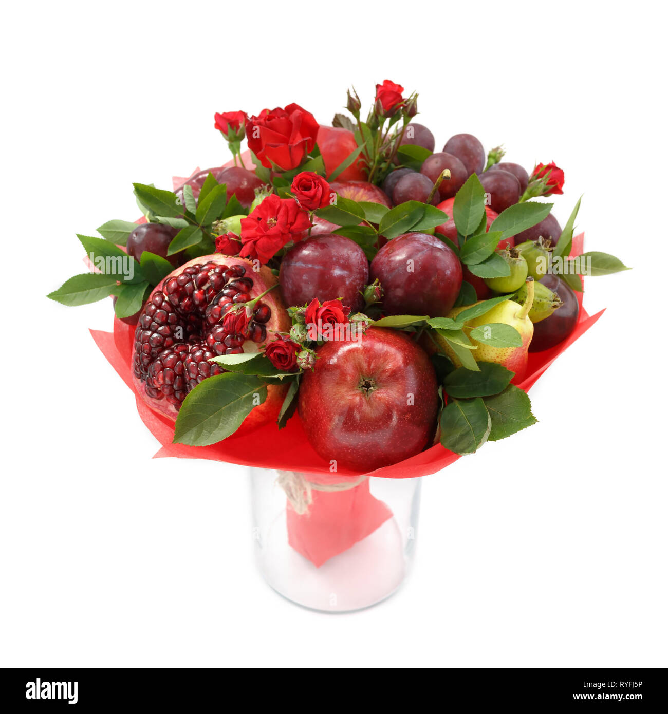 Originale bouquet fruttato composta di mele, prugne, pere, melograno e fiori di scarlet Rose in un vaso di vetro su uno sfondo bianco Foto Stock