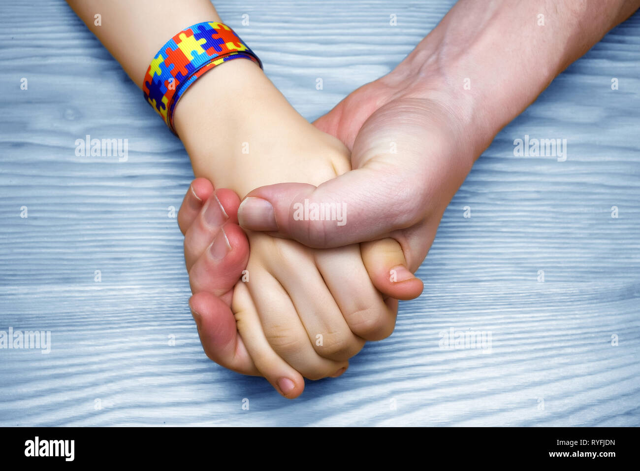 L'autismo consapevolezza dell'immagine. Padre tenendo la mano del suo bambino autistico Foto Stock