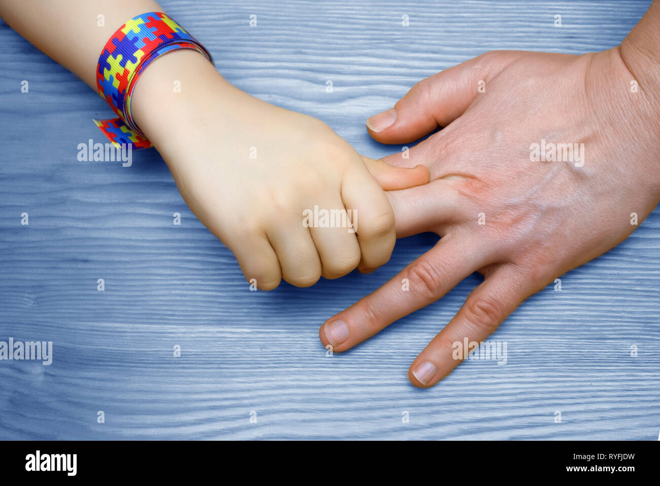 L'autismo consapevolezza dell'immagine. Padre tenendo la mano del suo bambino autistico Foto Stock