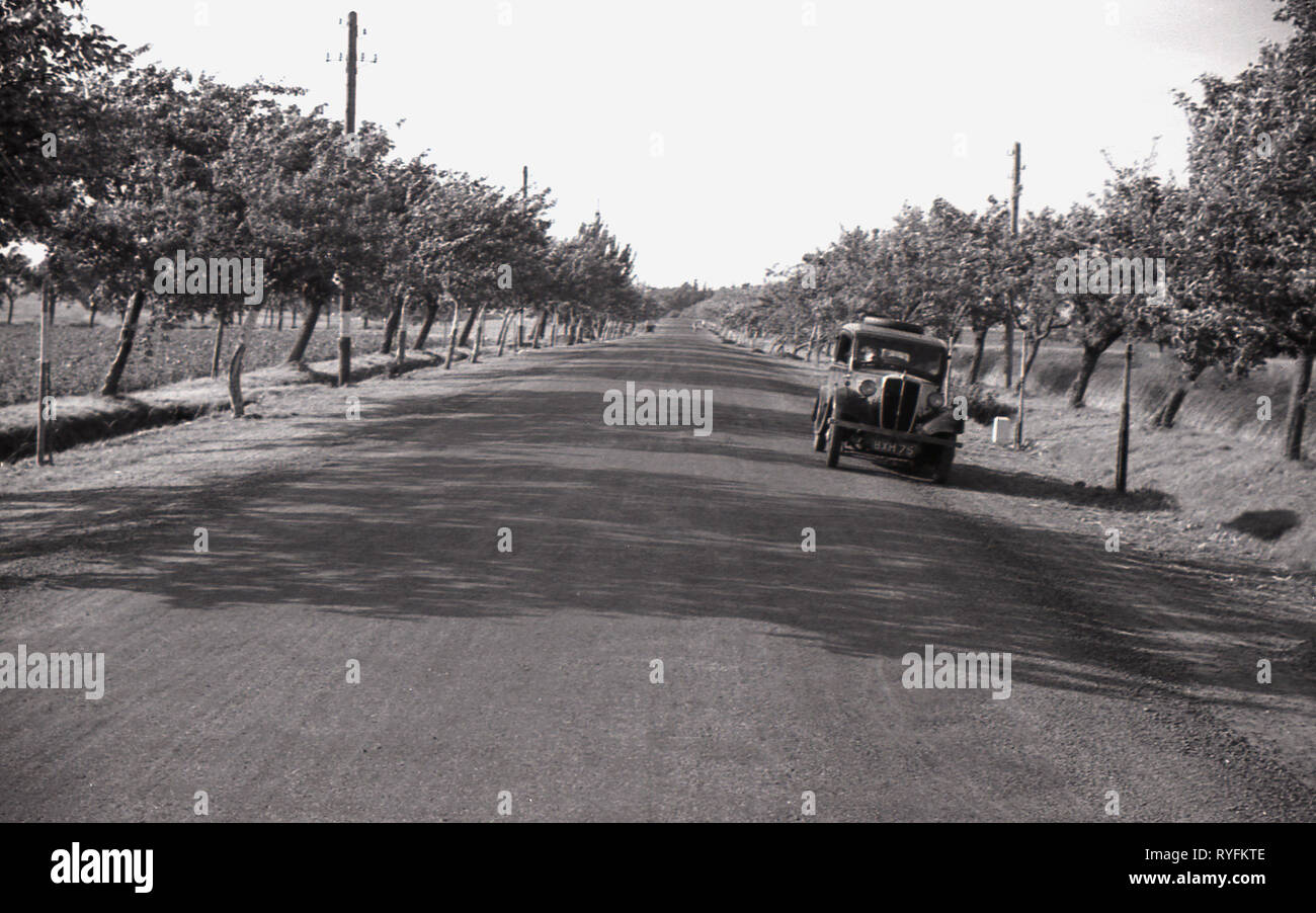 1930, la Cecoslovacchia, la vettura inglese dell'era parcheggiata su una vasta, dritto su strada asfaltata in un allevamento rurale distretto. Foto Stock