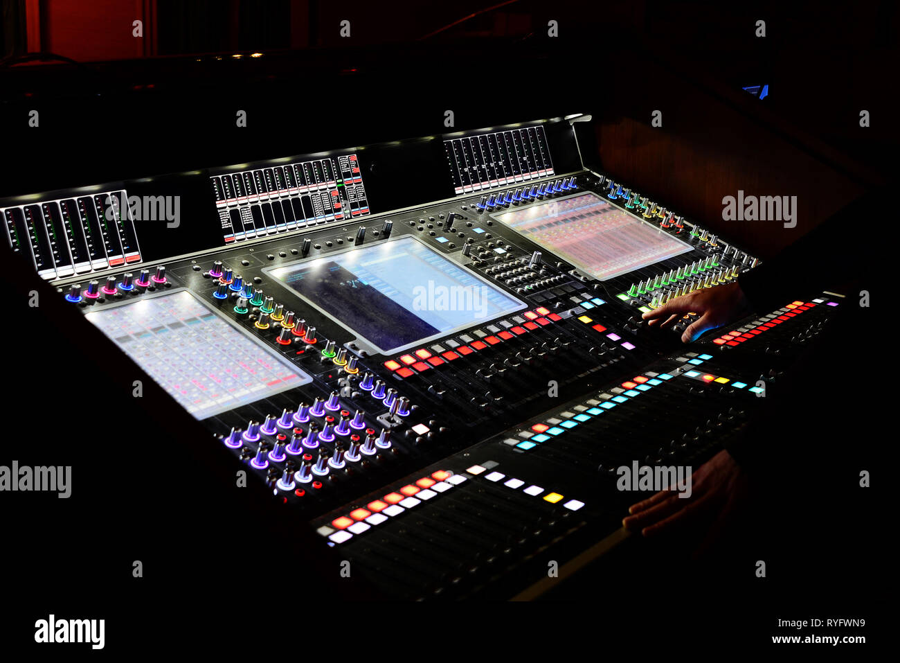 Maschio sono le mani su un Professional digital mixing console per il controllo del suono in uno studio di registrazione Foto Stock