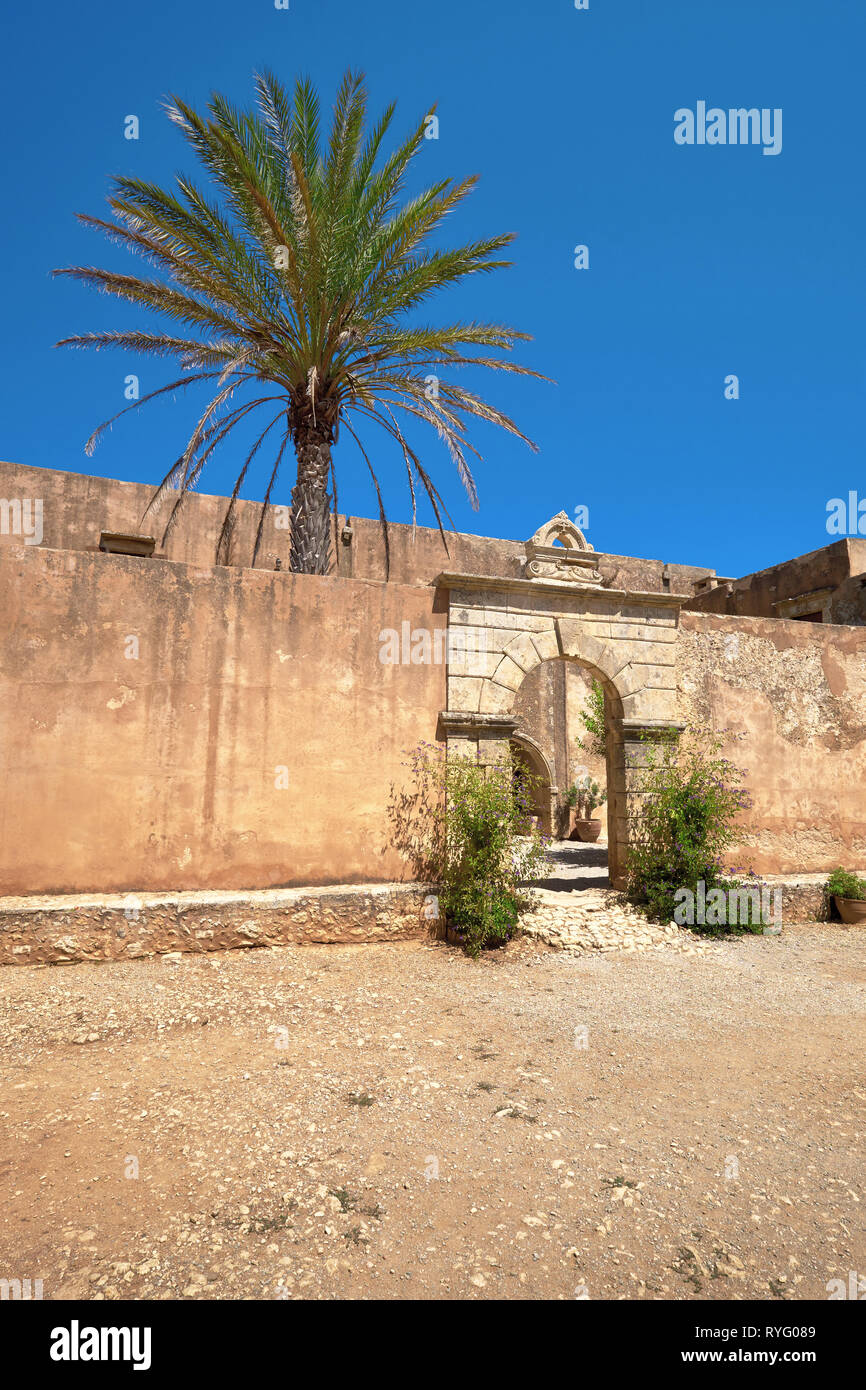 Monastero Arcadi in Creta, una palma dietro la parete e tradizionale edificio arcuato ingresso, copy-spazio Foto Stock
