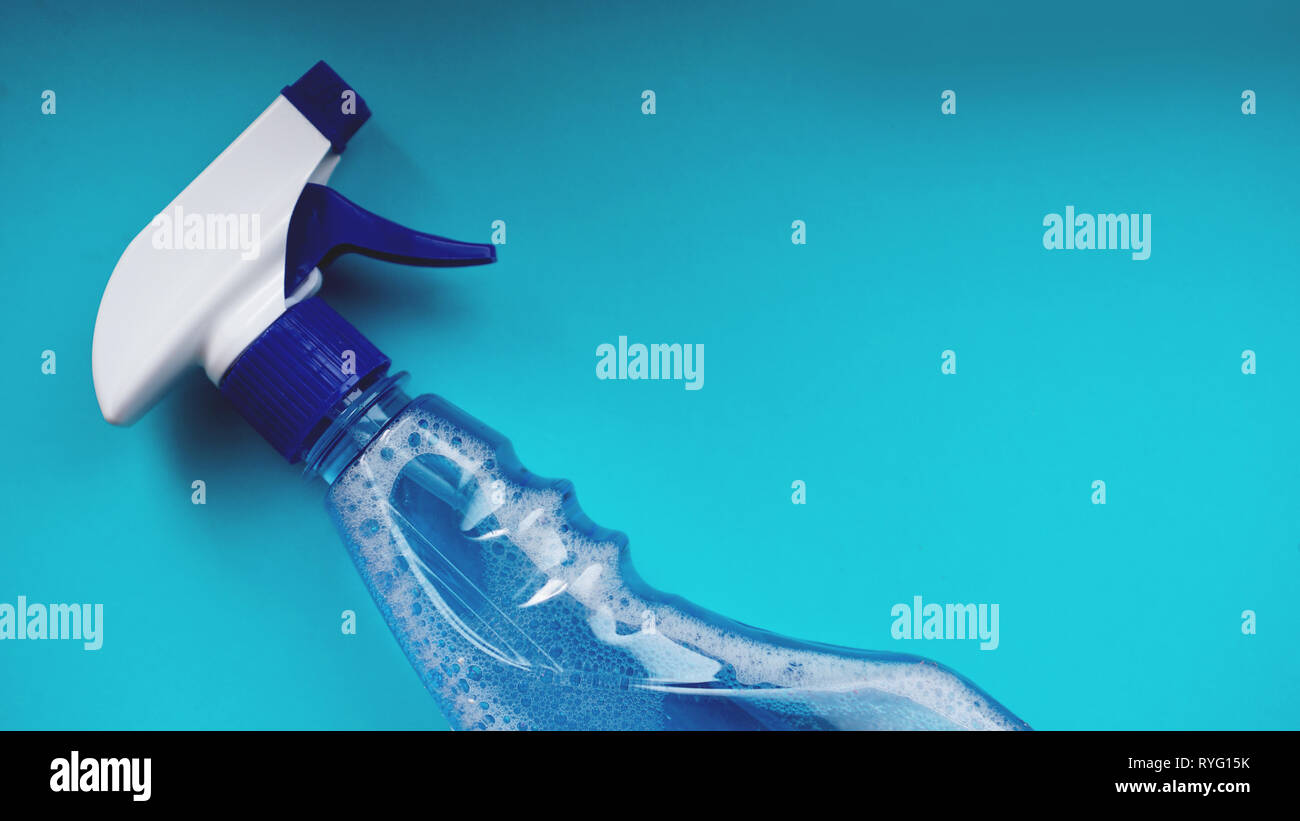 Spruzzare con detergente su sfondo blu. I lavori domestici e le pulizie e il concetto di uso domestico Foto Stock