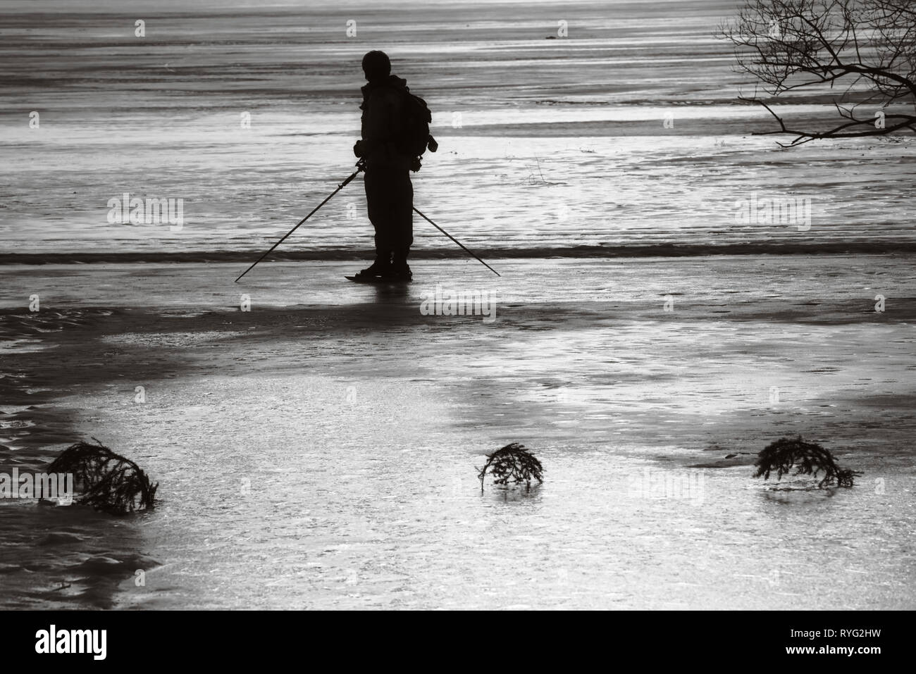 In bianco e nero della silhouette a lunga distanza Skater ghiaccio sul lago Malaren, Sigtuna, Svezia e Scandinavia Foto Stock