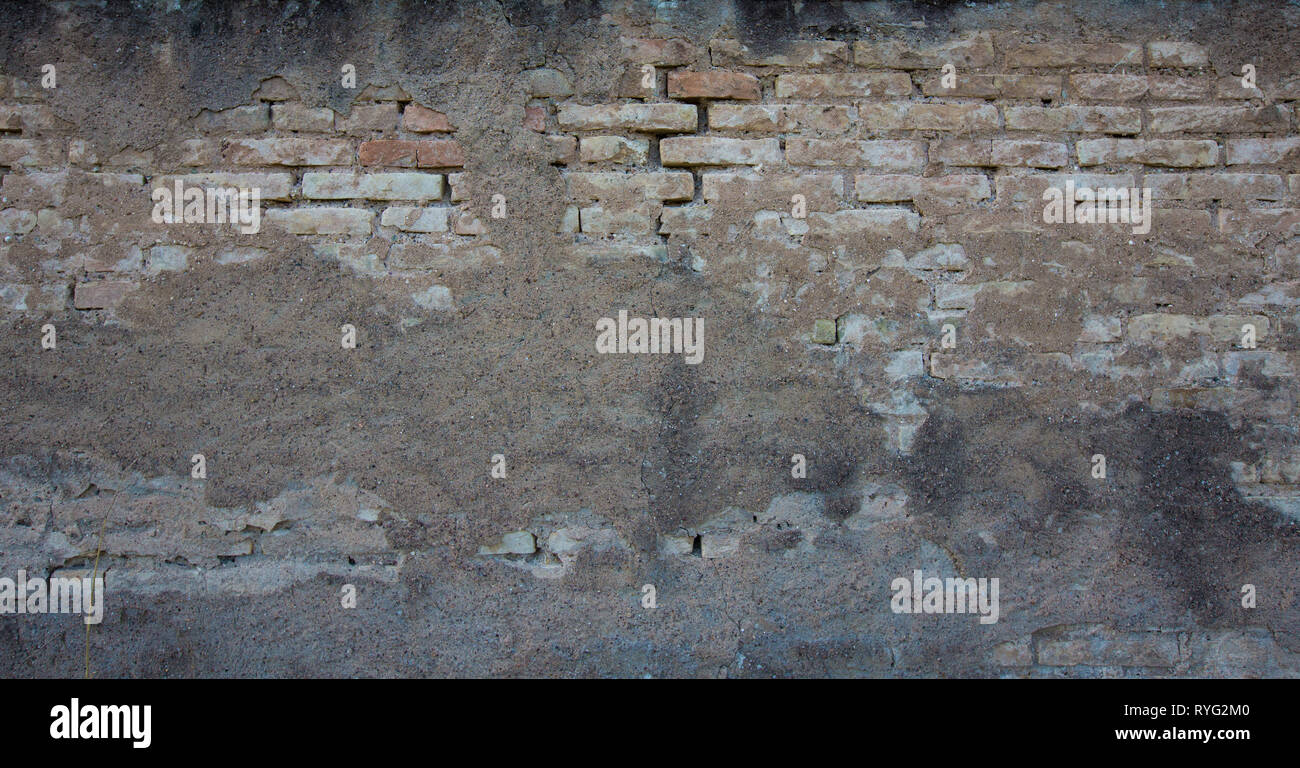 Weathered intonaco ed intonacando sopra un mattone vintage parete in muratura. Abstract vecchio cemento texture, antica struttura sfondo con difetti naturali. St Foto Stock