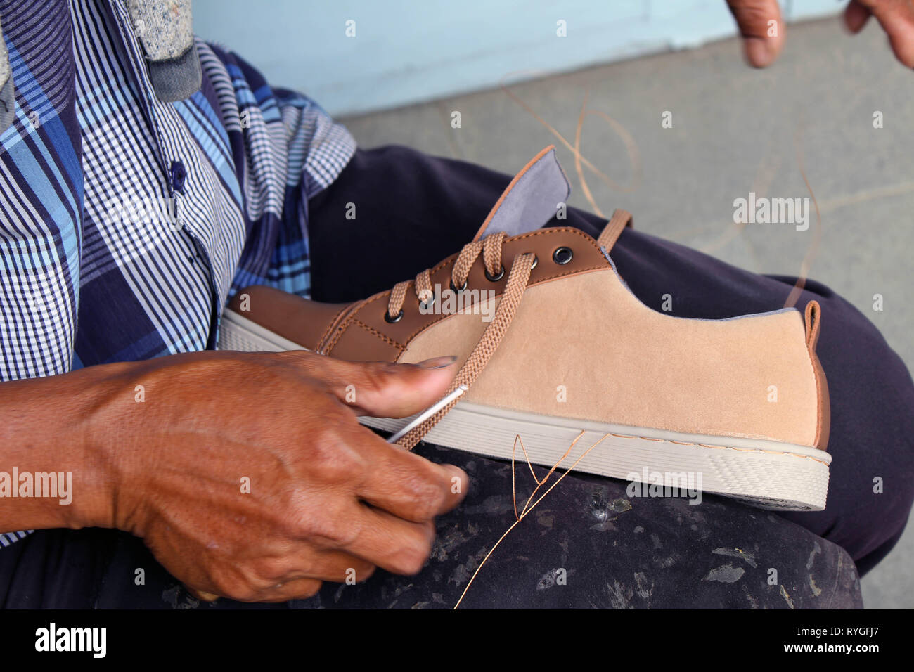 Processo di scarpa manuale Riparazione, suola e welt di fissaggio e di cucitura. Preso in Indonesia. Foto Stock