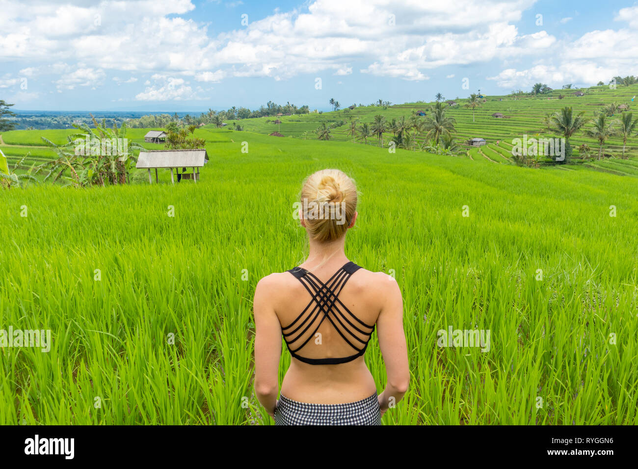 Rilassato e informale donna sportivo godendo di pura natura di splendidi e verdi risaie di Bali. Foto Stock