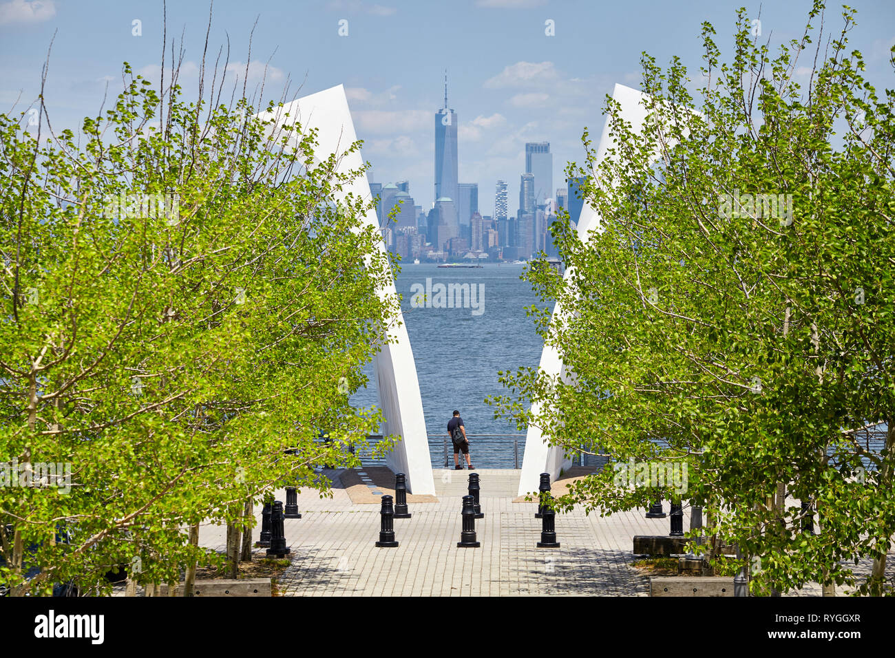 New York, Stati Uniti d'America - 29 Giugno 2018: l uomo sta tra cartoline, Staten Island 11 Settembre Memorial con Manhattan in distanza. Foto Stock