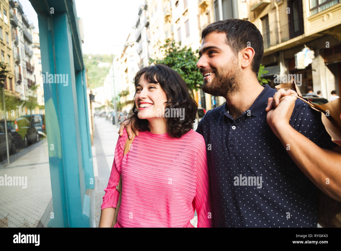Felice e attraente coppia giovane guardando vetrine sorridente Foto Stock