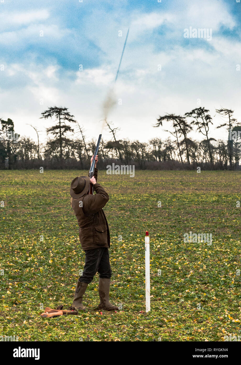 Un uomo che ha appena sparato un colpo di pistola e la colonna di colpo può essere visto lasciare la estremità del cilindro Foto Stock